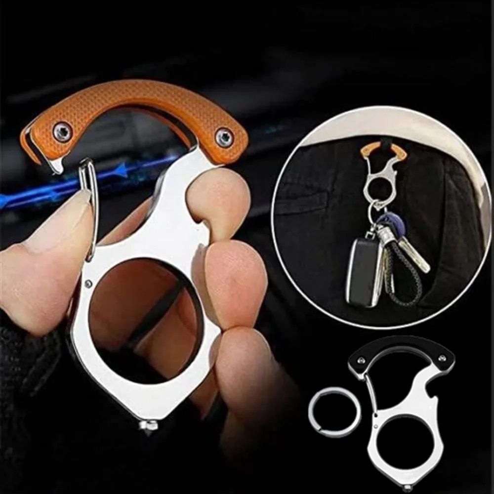 Edelstahl-Karabiner mit orangem Griff in der Hand, daneben ein Autoschlüssel am Gürtel und das Modell mit schwarzem Griff samt Schlüsselring. 2