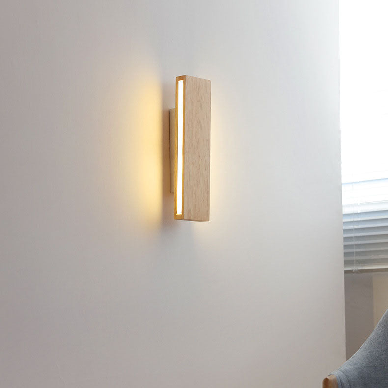 Eingeschaltete senkrechte Holzleuchte mit leuchtendem Seitenstreifen an einer weißen Wand neben einem Fenster und einem Stuhl. 15