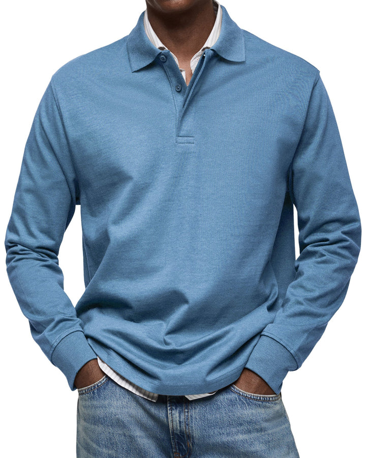 Langarm-Poloshirt in Hellblau, getragen mit gestreiftem Hemd und Jeans, Frontansicht mit Knopfleiste und Rippbündchen. 2