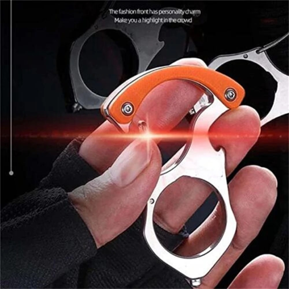 Hand hält den Karabiner-Schlüsselanhänger aus Edelstahl mit orangem Griffteil, die Finger greifen durch die große runde Öffnung. 1