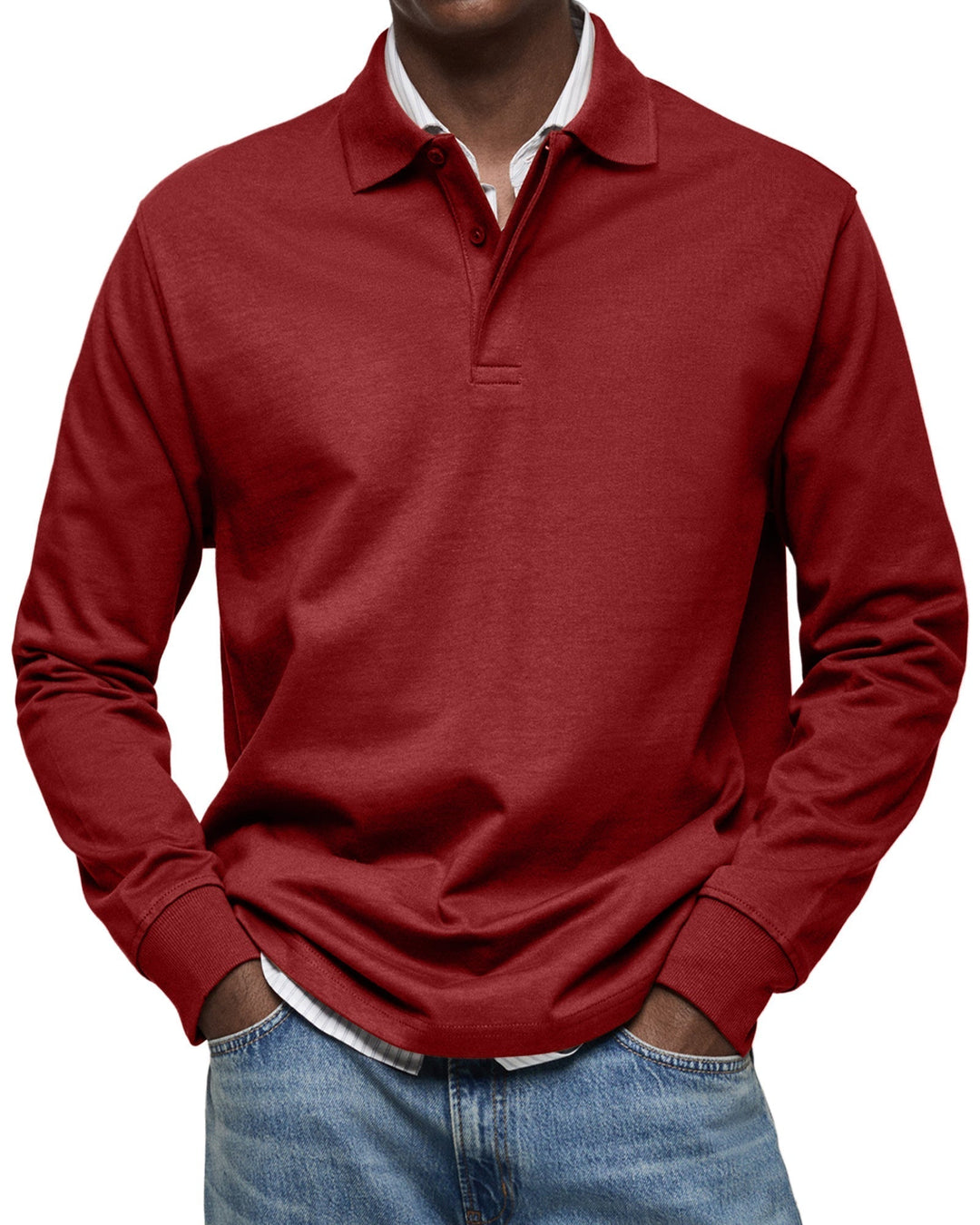Langarm-Poloshirt in Dunkelrot, am Model getragen, gestreiftes Hemd darunter, Hände in den Taschen der Jeans. 11