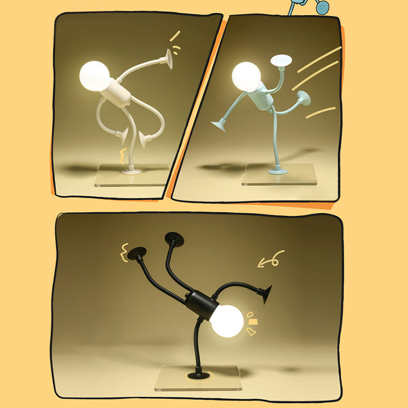 Drei comicartig gerahmte Szenen zeigen die leuchtende Figurenlampe in Weiß, Hellblau und Schwarz in Tritt- und Handstandposen auf Glasplatten. 1