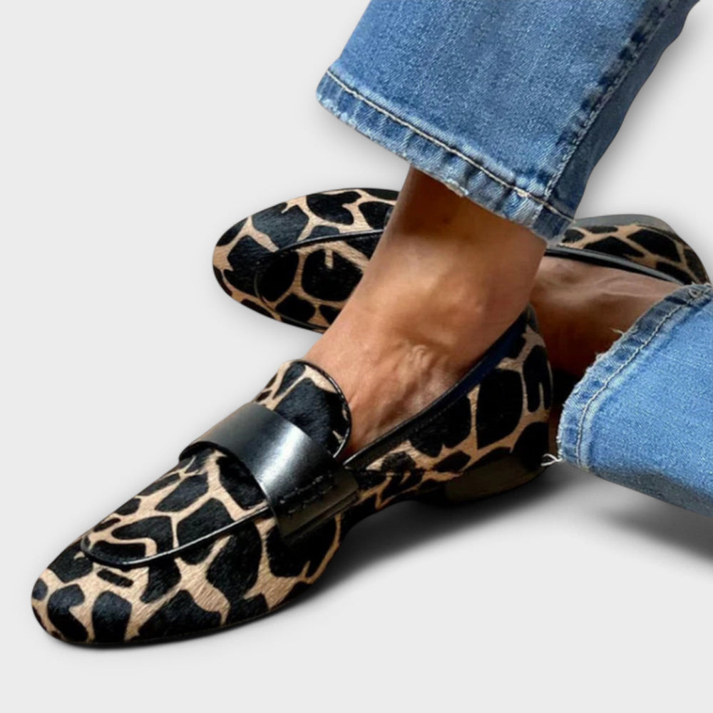 Naher Blick auf den Loafer am Fuß mit gekrempelter Jeans: Fellmuster, schwarzes Querband und runde Schuhspitze im Detail. 2