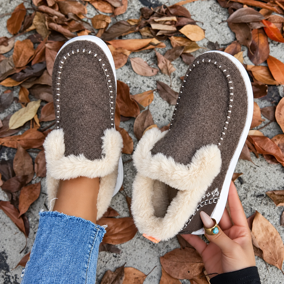 Braune Slip-On-Sneaker von oben, einer getragen, einer in der Hand mit sichtbarem weichem Plüschfutter im Inneren. 8