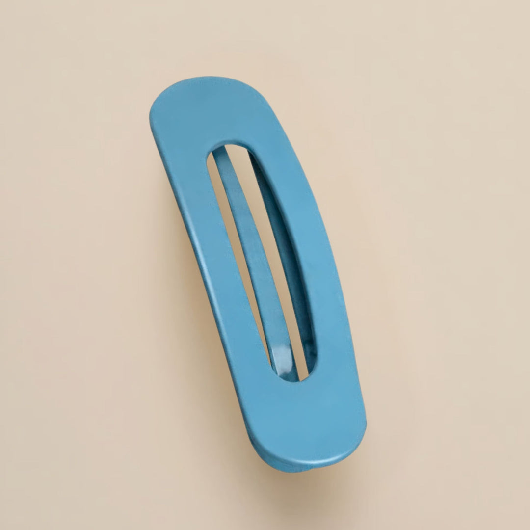 Matte Haarspange in mittlerem Blau mit länglichem Ausschnitt, von oben auf beigem Untergrund 14