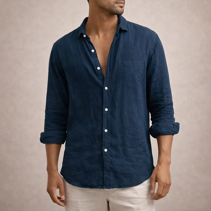 Marineblaues Leinenhemd mit aufgesetzter Brusttasche und weißen Knöpfen, Model in Frontansicht mit hochgekrempelten Ärmeln und heller Hose. 7