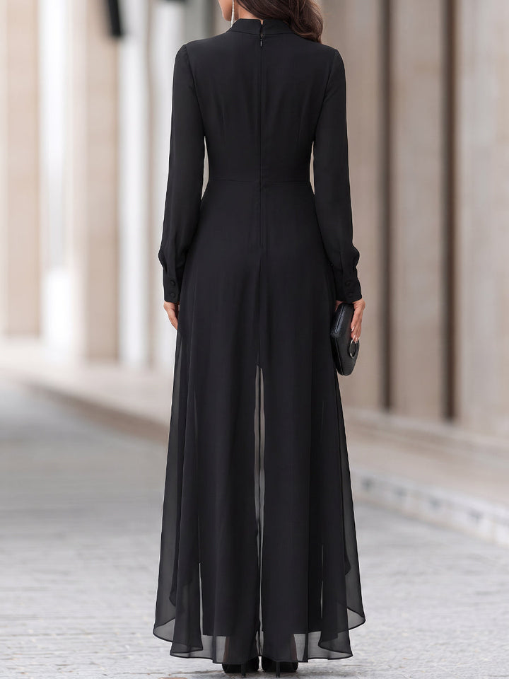 Rückansicht des schwarzen Outfits mit Reißverschluss im Rücken, geknöpften Manschetten und fließendem, transparentem Chiffon-Überrock. 5