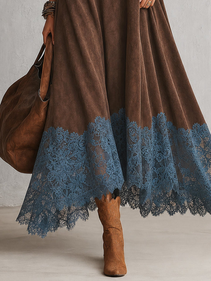 Detailansicht des blauen Spitzenbesatzes am Saum des braunen Kleids, dazu braune Stiefel 3
