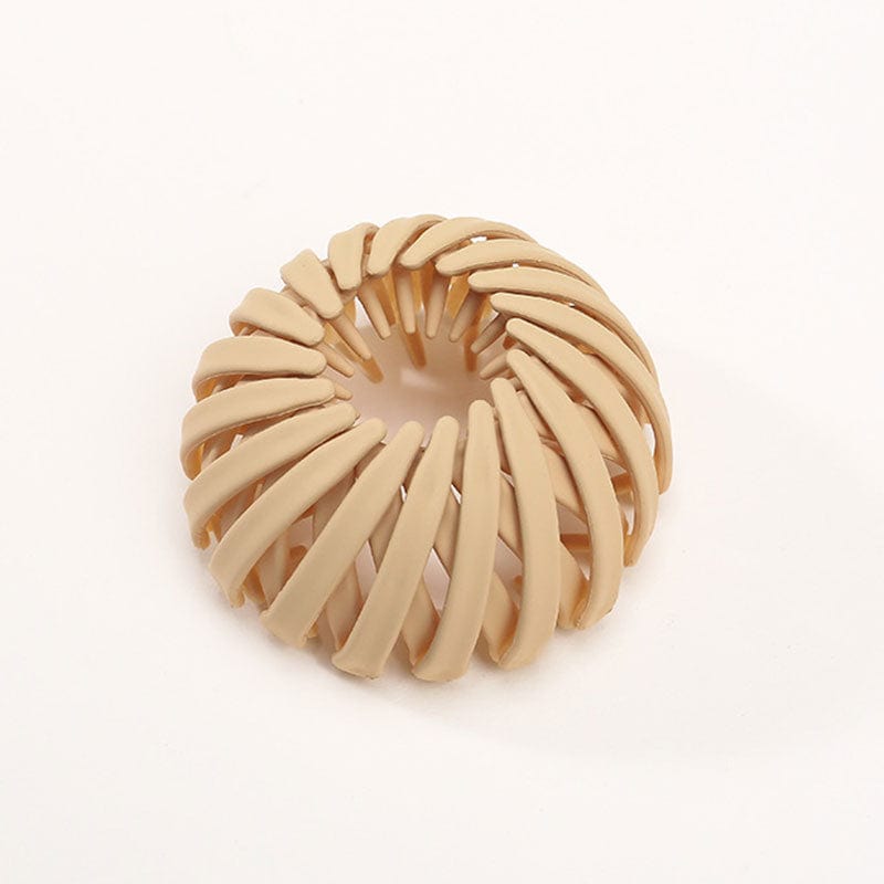 Einzelne matte Klammer in Sandbeige mit spiralförmigen Streben, freigestellt auf hellem Hintergrund. 16