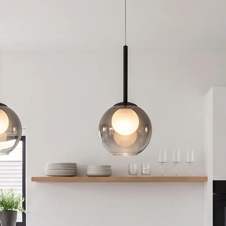 Nahaufnahme einer rauchgrauen Pendelleuchte über einem Holzregal mit Tellern, Gläsern und Weingläsern in der Küche 11