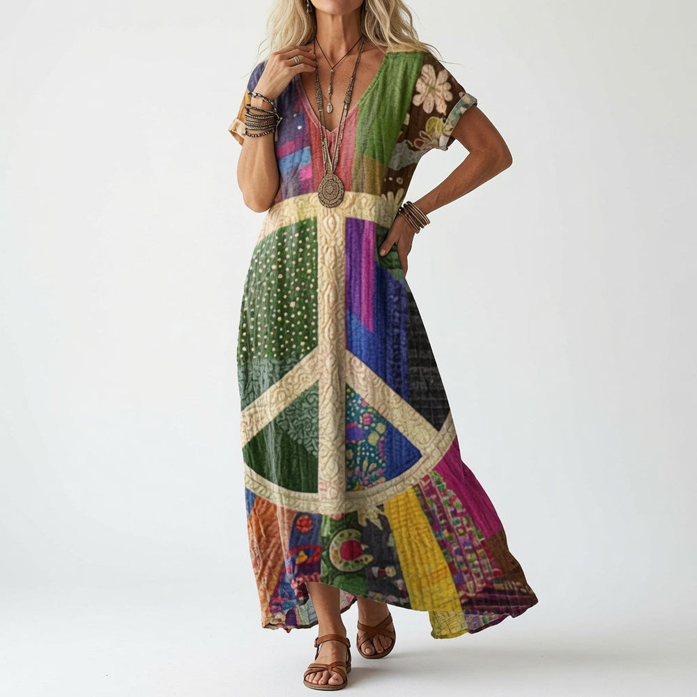 Frau trägt die bunte Patchwork-Variante mit großem Friedenszeichen-Motiv auf der Vorderseite, dazu Armreife, Kette und braune Riemensandalen. 2