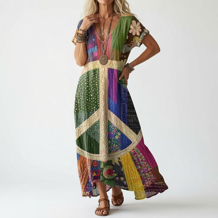 Frau trägt die bunte Patchwork-Variante mit großem Friedenszeichen-Motiv auf der Vorderseite, dazu Armreife, Kette und braune Riemensandalen. 2
