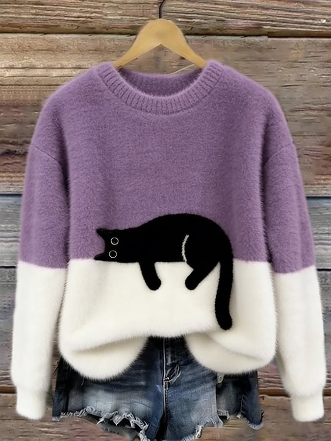 Flauschiger Pullover in Flieder mit weißem Unterteil und aufgenähter schwarzer Katze, an Holzbügel vor Holzwand 10