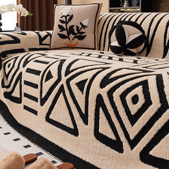Beiger Bezug mit schwarzem geometrischem Muster aus Dreiecken und Rauten, dazu Blumenkissen und rundes Kissen 17