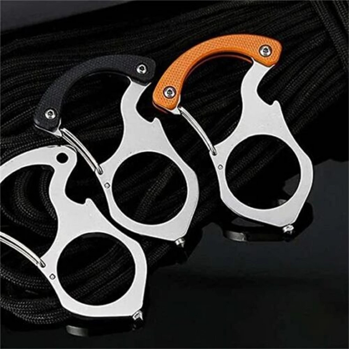 Drei Edelstahl-Karabiner mit orangem, schwarzem und ohne Griffteil nebeneinander auf geflochtenem schwarzem Seil. 3