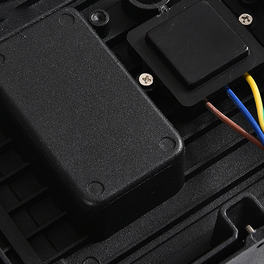 Blick ins Innere des Gehäuses mit schwarzem Elektronikgehäuse, Schrauben und farbigen Anschlusskabeln in Gelb, Blau und Braun. 7