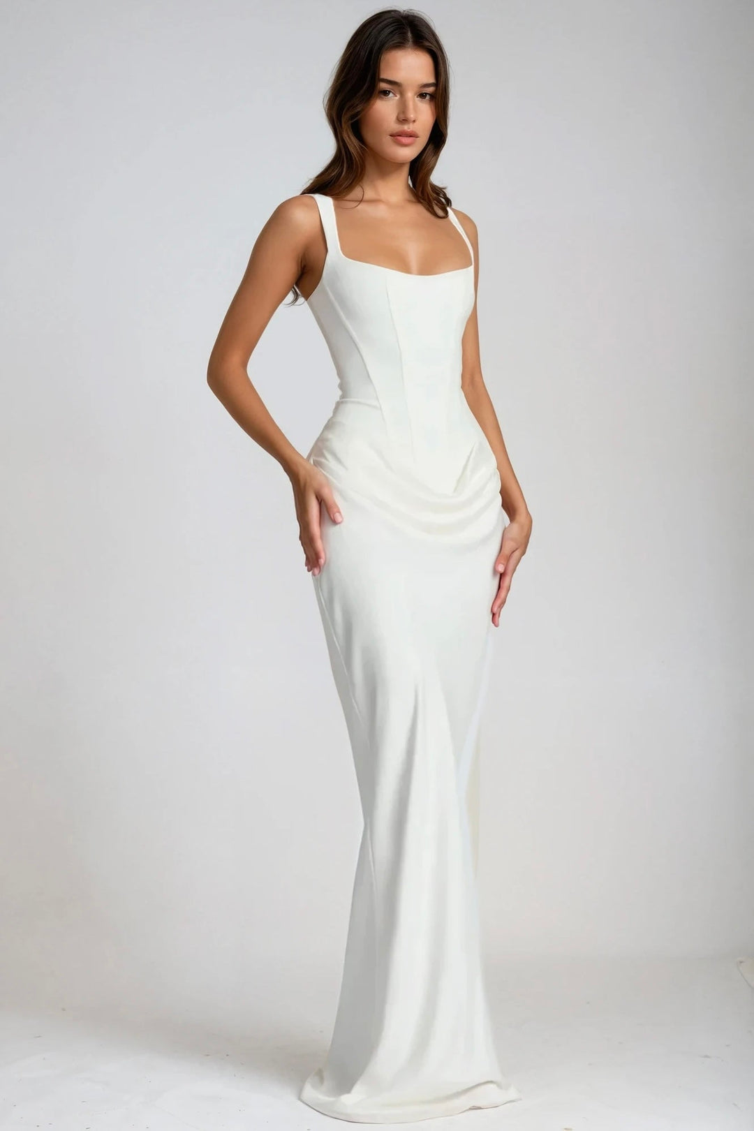 Weißes Maxikleid mit Korsagenschnitt und gerafftem Hüftdetail, seitlich schräg von einem Model getragen 2