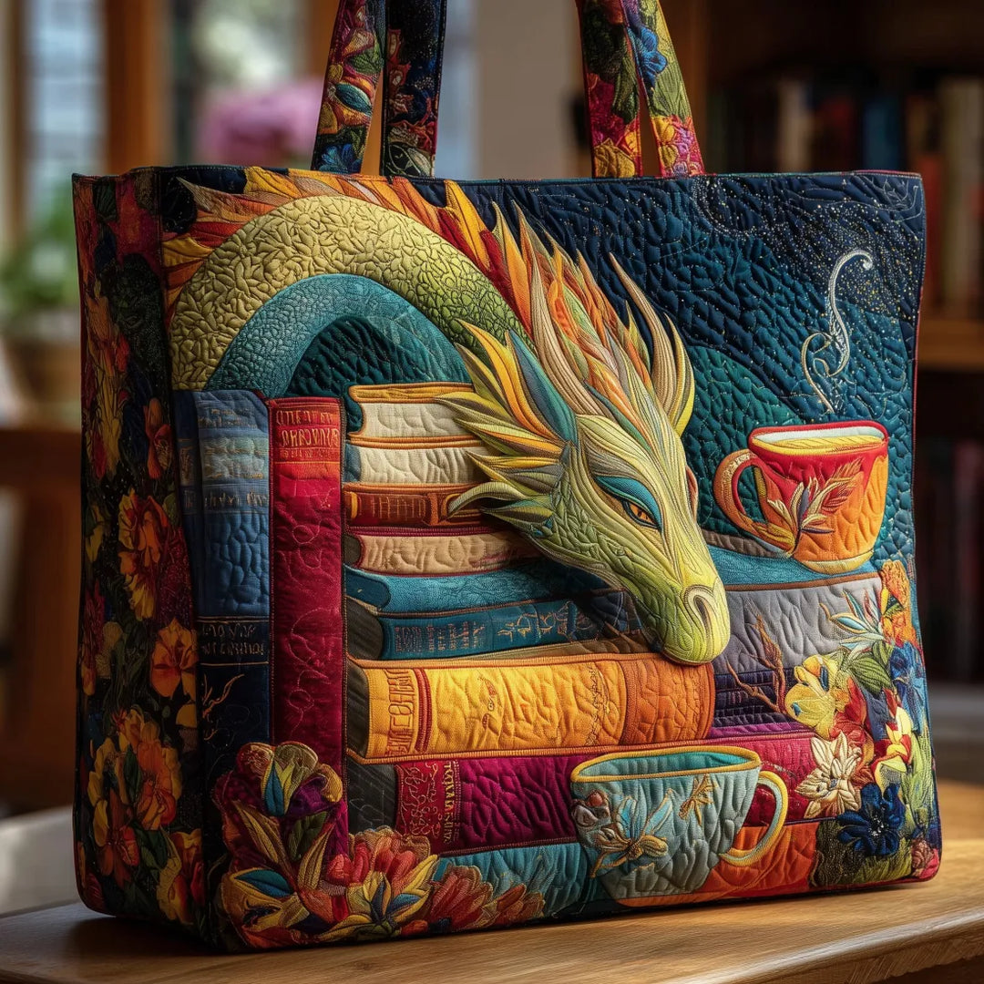 Bunt gesteppte Tragetasche mit Drachenkopf auf einem Bücherstapel, daneben Teetassen und Blumen, auf einem Holztisch vor Bücherregal fotografiert. 1