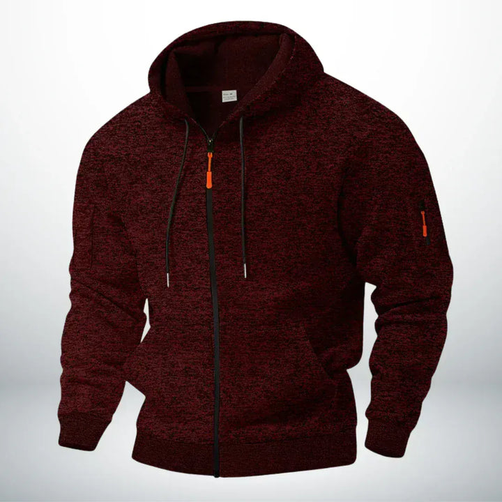 Dieselbe Kapuzenjacke in meliertem Weinrot, frontal von schräg gezeigt, mit orangefarbenem Zipper und Ärmeltasche. 2