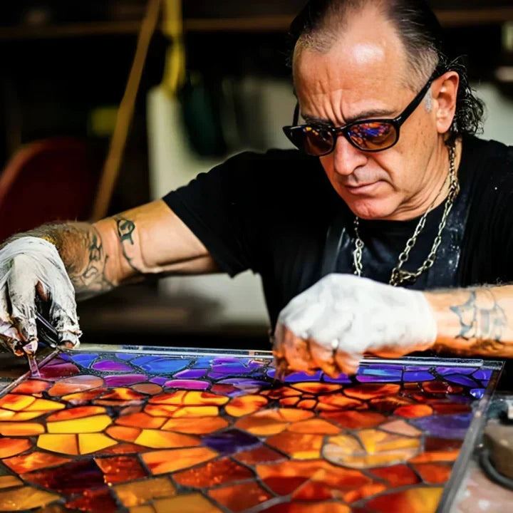 Handwerker mit Sonnenbrille setzt bunte Glasstücke zu einem Mosaik zusammen, Herstellung der Lampe 2