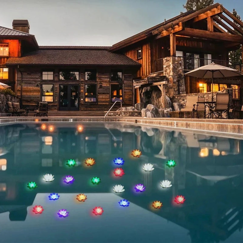 Abendlicher Pool vor einem Holzhaus, auf dem Wasser schwimmen viele bunt leuchtende Lotusblüten in verschiedenen Farben 7
