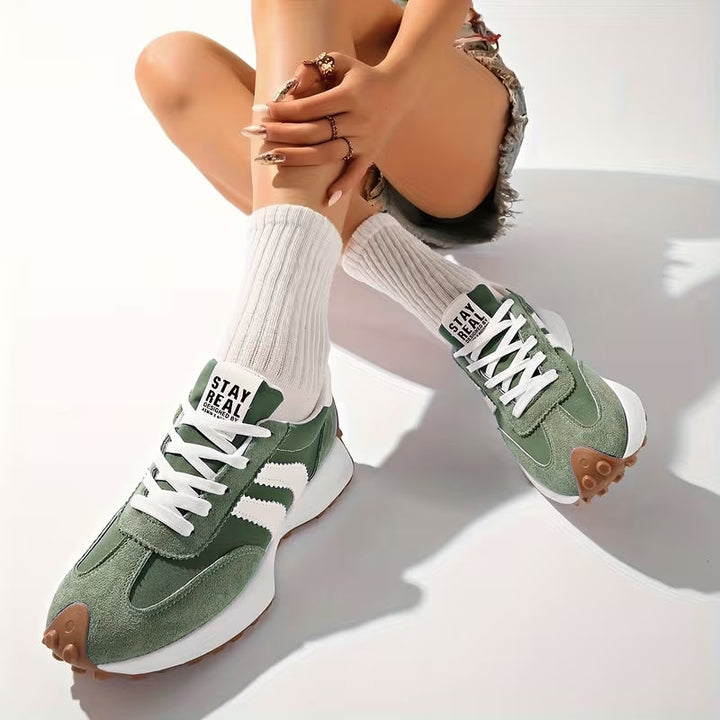Grüne Wildleder-Sneaker, von einer sitzenden Frau mit weißen Rippensocken in Jeansshorts getragen 7