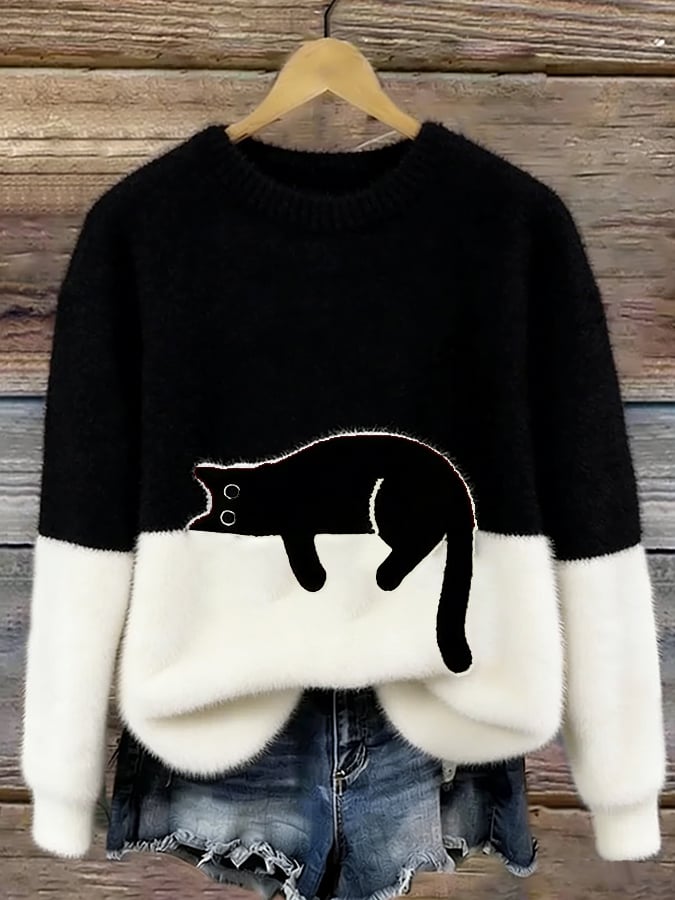 Flauschiger Pullover in Schwarz mit weißem Unterteil und aufgenähter schwarzer Katze, an Holzbügel vor Holzwand 5