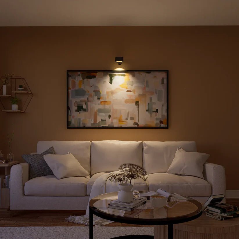 Schwarze Wandlampe über einem großen abstrakten Gemälde leuchtet das Bild über einem hellen Sofa im Wohnzimmer an. 8
