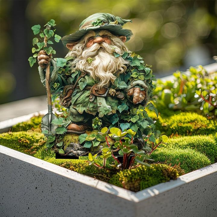 Gartenzwerg mit Bart und Spaten in einem Betonkasten mit Moos und kleinen Pflanzen im Sonnenlicht. 15
