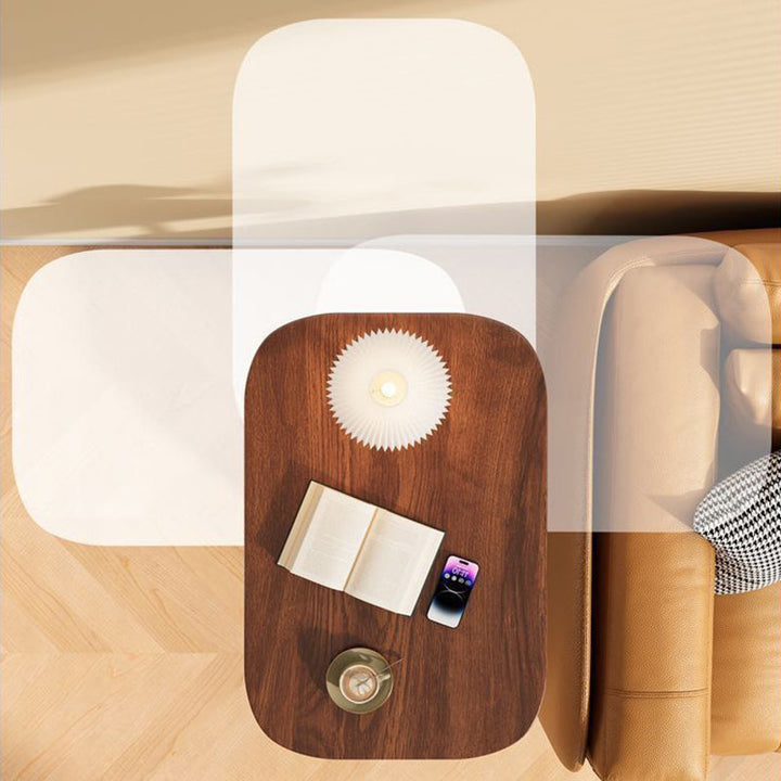 Draufsicht auf die Holzplatte mit Buch, Lampe, Smartphone und Tasse neben dem Sofa; transparente Umrisse zeigen die Drehung der Platte. 7