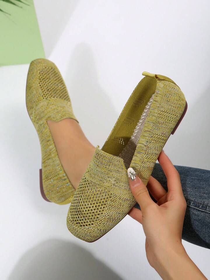 Gelbgrüne Mesh-Slip-ons, ein Schuh in der Hand gehalten mit Blick auf Innenfußbett und Fersenlasche. 19
