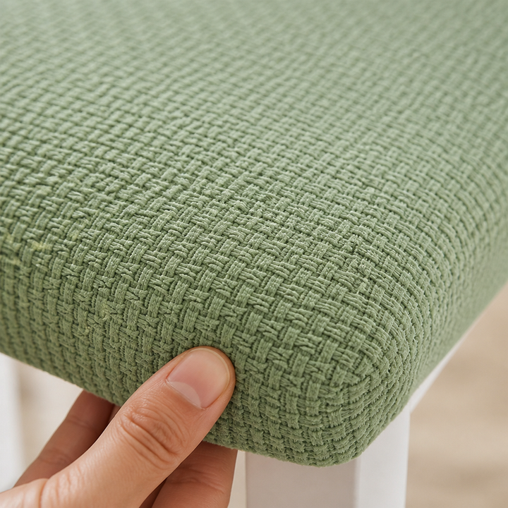 Extreme Nahaufnahme der grünen, geflochten wirkenden Jacquard-Textur an der Sitzkante, ein Daumen drückt in den Stoff. 4