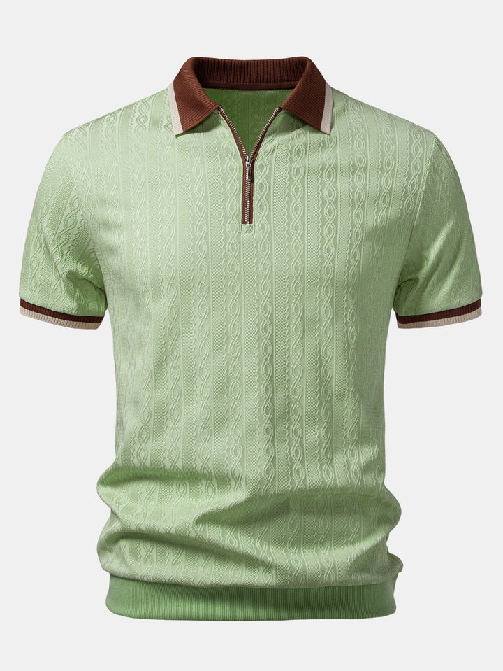 Vorderansicht des hellgrünen Strickpoloshirts mit braunem Kontrastkragen, Reißverschluss am Ausschnitt und plastischem Zopfmuster. 7