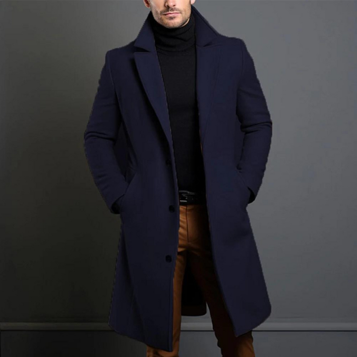 Marineblauer langer Mantel mit Reverskragen und Knopfleiste, kombiniert mit schwarzem Rollkragenpullover und brauner Hose, Frontansicht am Model. 4
