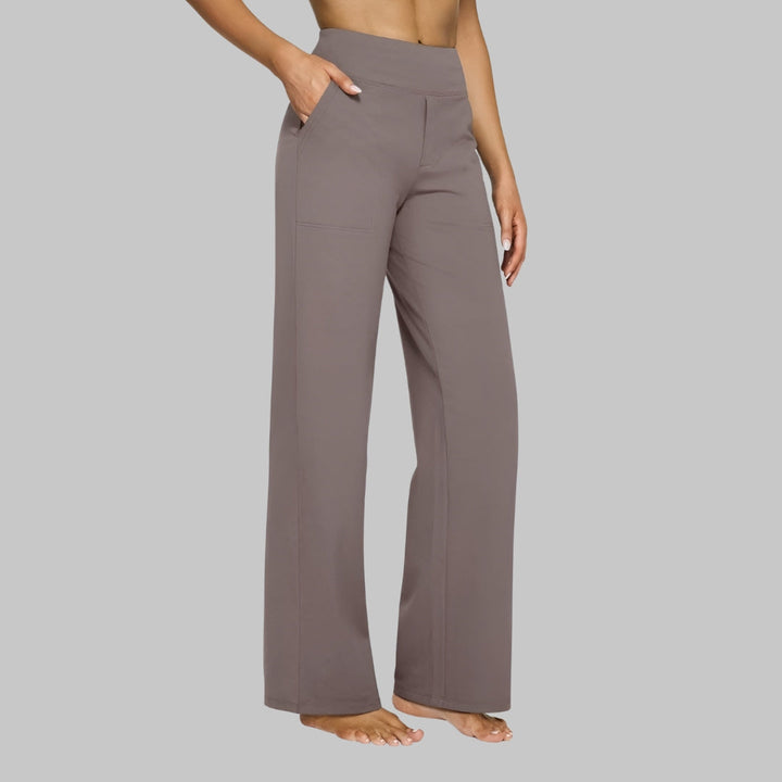 Seitenansicht der Hose in Taupe, getragen von einem Model barfuß mit einer Hand in der Seitentasche. 1