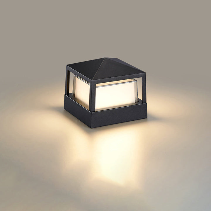 Quadratische schwarze Leuchte mit Pyramidendach und leuchtendem Diffusor, die den Untergrund warm erhellt. 10