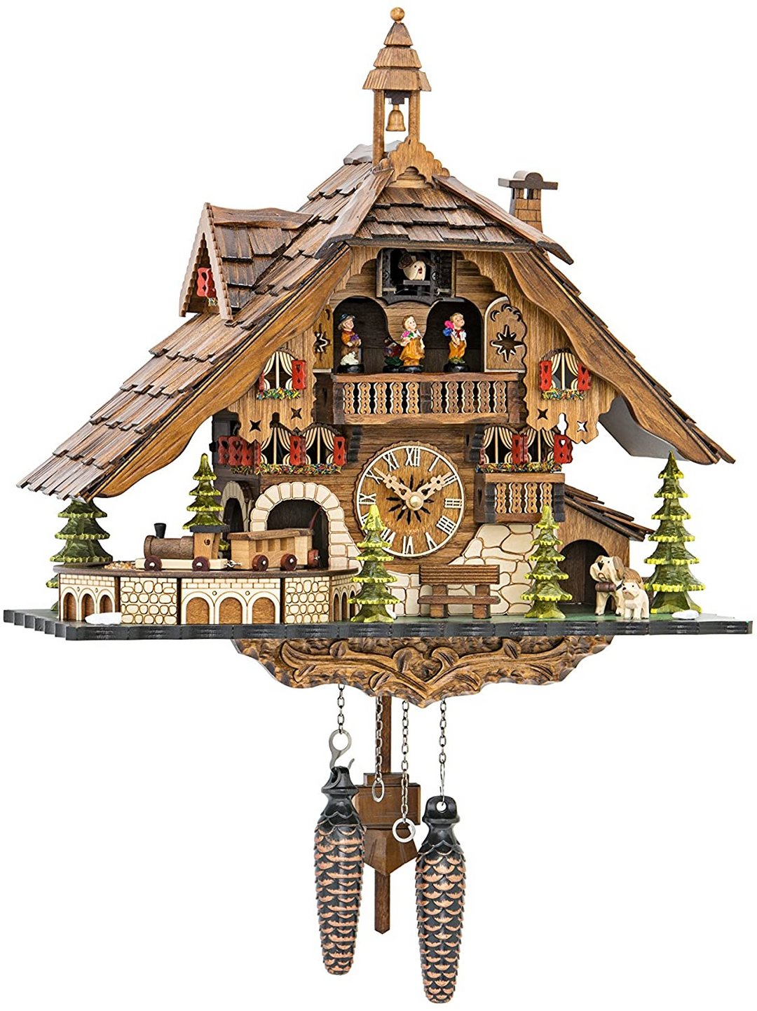 Frontansicht der Chalet-Kuckucksuhr mit Schindeldach, Glockenturm, Balkon mit Figuren, Spielzeugeisenbahn, Tannen, Hunden und zwei tannenzapfenförmigen Gewichte 1