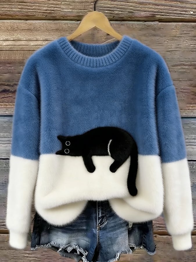 Flauschiger Pullover in Mittelblau mit weißem Unterteil und aufgenähter schwarzer Katze, an Holzbügel vor Holzwand 8