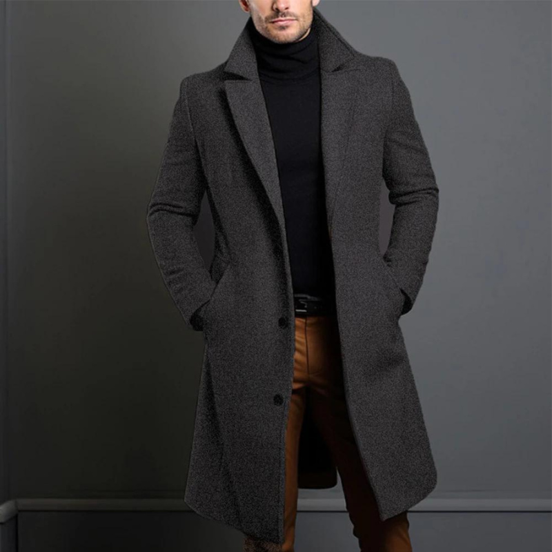 Dunkelgrauer, leicht melierter langer Mantel mit Reverskragen, getragen über schwarzem Rollkragenpullover und brauner Hose. 3