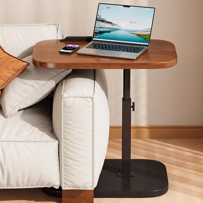 Tisch mit Laptop und Smartphone, dessen Platte über die Sofakante ragt, sodass der Fuß unter dem Sofa Platz findet. 11
