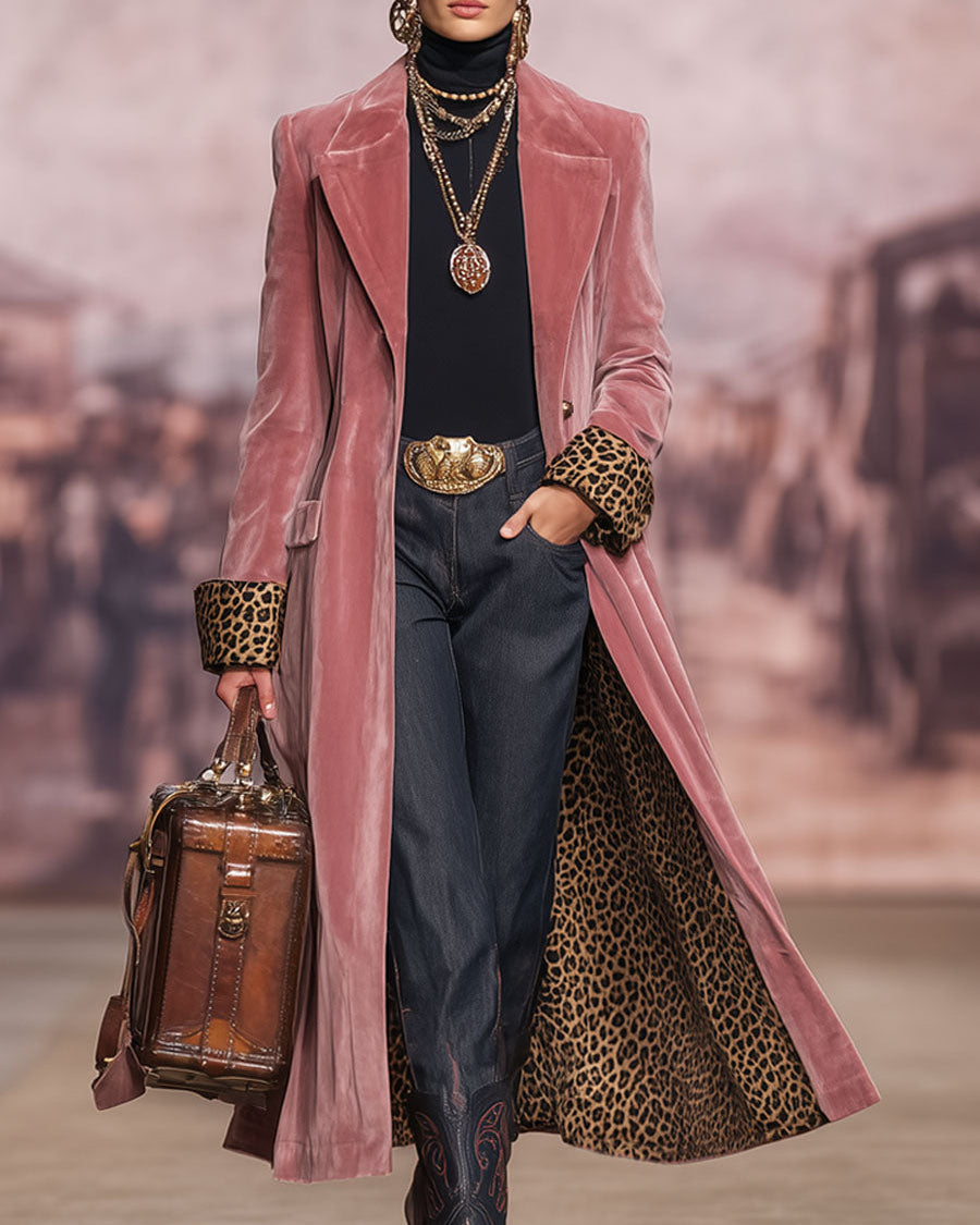 Model auf dem Laufsteg trägt den rosa Samtmantel offen, die Hand in der Jeanstasche, mit Lederkoffertasche und Goldketten. 3