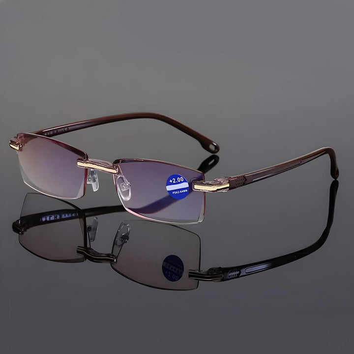 Lesebrille mit braunen Bügeln und goldfarbenen Beschlägen auf spiegelnder grauer Fläche, die Farbvariante Braun im Vergleich zu Schwarz. 7