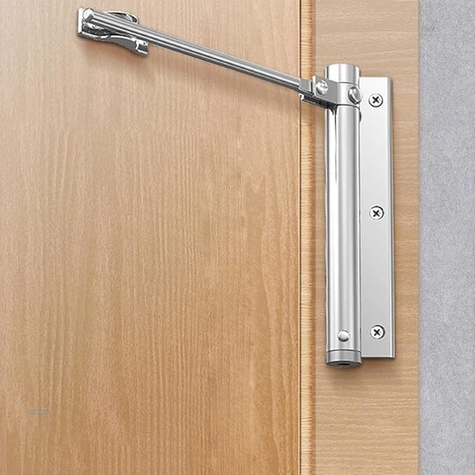 Silberner Türschließer in Seitenansicht an einer Holztür, Arm und Befestigungsplatte mit Schrauben gut erkennbar 2