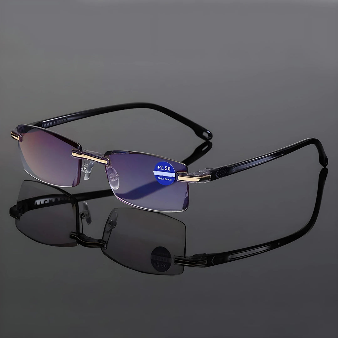 Lesebrille mit schwarzen Bügeln und goldfarbenen Beschlägen auf spiegelnder dunkler Fläche, mit deutlich sichtbarer Spiegelung darunter. 6