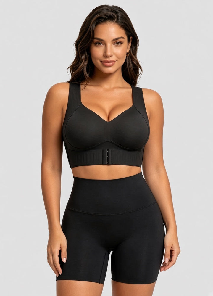 Frontansicht des schwarzen BHs am Model mit V-Ausschnitt, breiten Trägern und Haken-Verschluss vorn, dazu schwarze hohe Shorts. 13