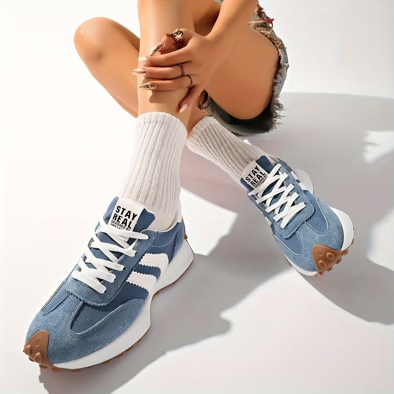 Blaue Wildleder-Sneaker, von einer sitzenden Frau mit weißen Rippensocken in Jeansshorts getragen 9