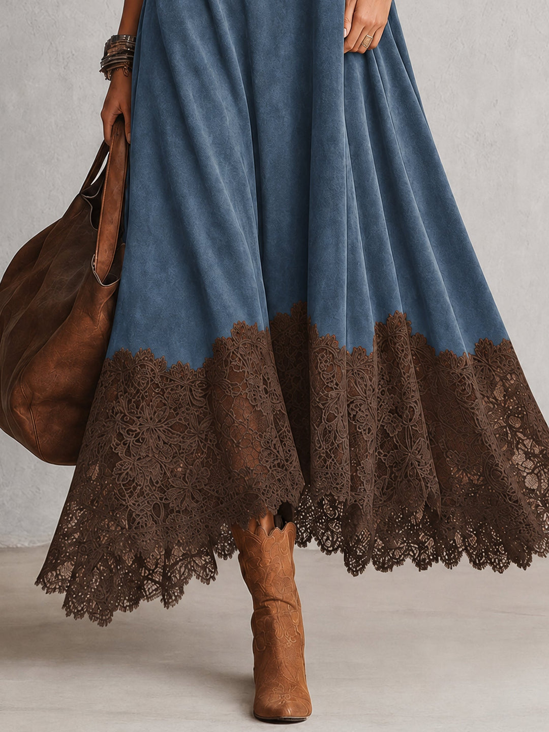 Detail des braunen Spitzenbesatzes am Saum des blauen Kleids, dazu Stiefel 12
