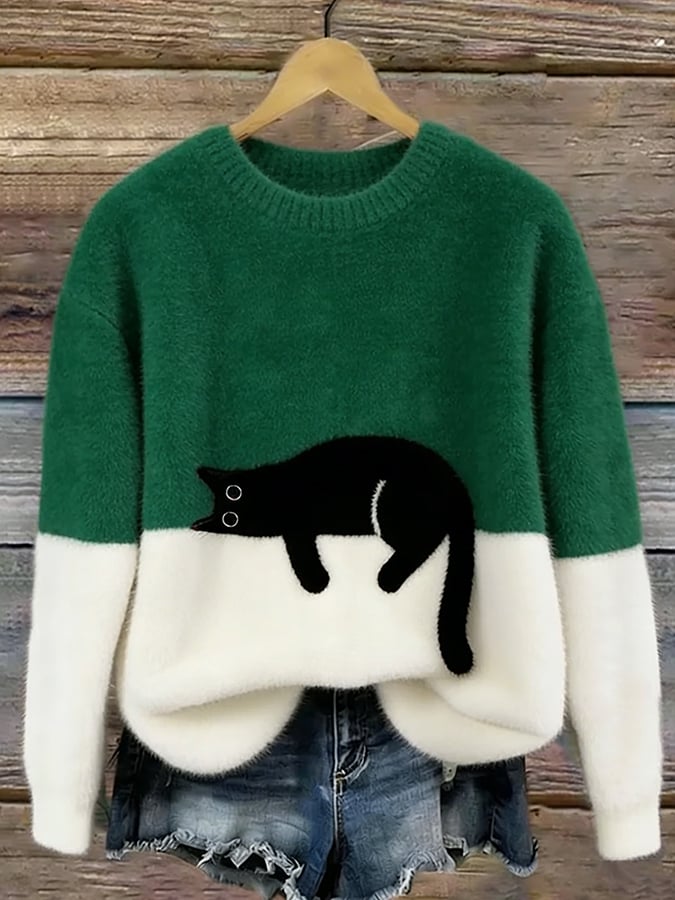 Flauschiger Pullover in Dunkelgrün mit weißem Unterteil und aufgenähter schwarzer Katze, an Holzbügel vor Holzwand 4