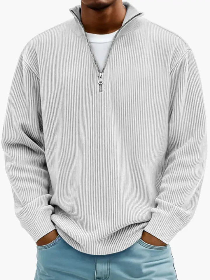 Frontansicht des gerippten Pullovers in sehr hellem Grau, getragen über weißem Shirt, mit lockerem Sitz und Stehkragen. 6