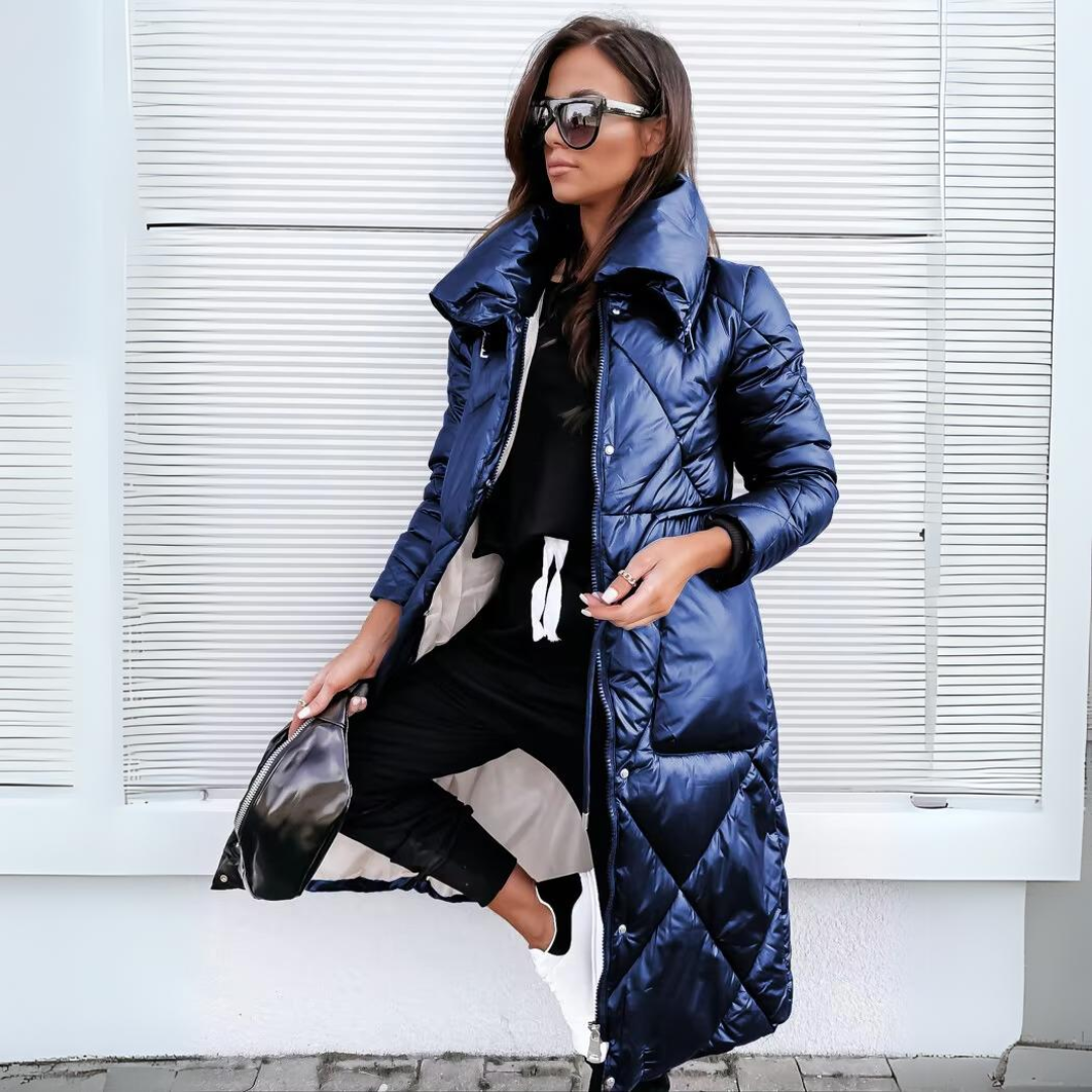 Lange Steppjacke in glänzendem Dunkelblau, offen getragen über schwarzem Outfit, mit hohem Kragen und Rautensteppung. 3